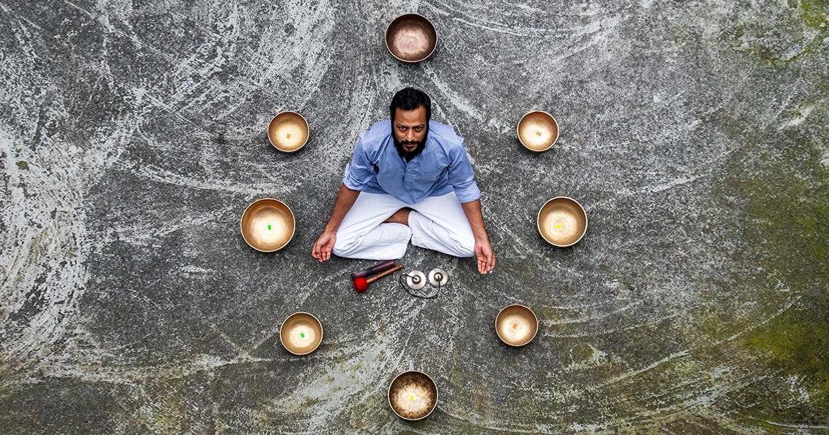 a man meditating with yoga and healing bowl