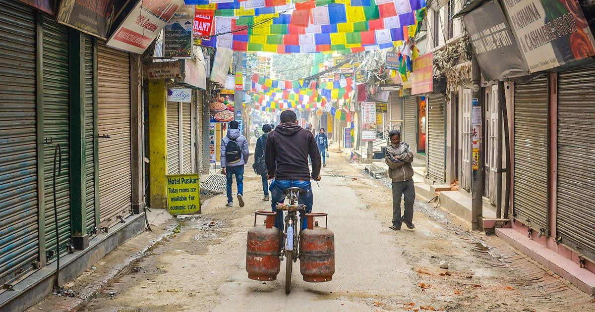 A man carrying a cylinder on the streets of Thamel