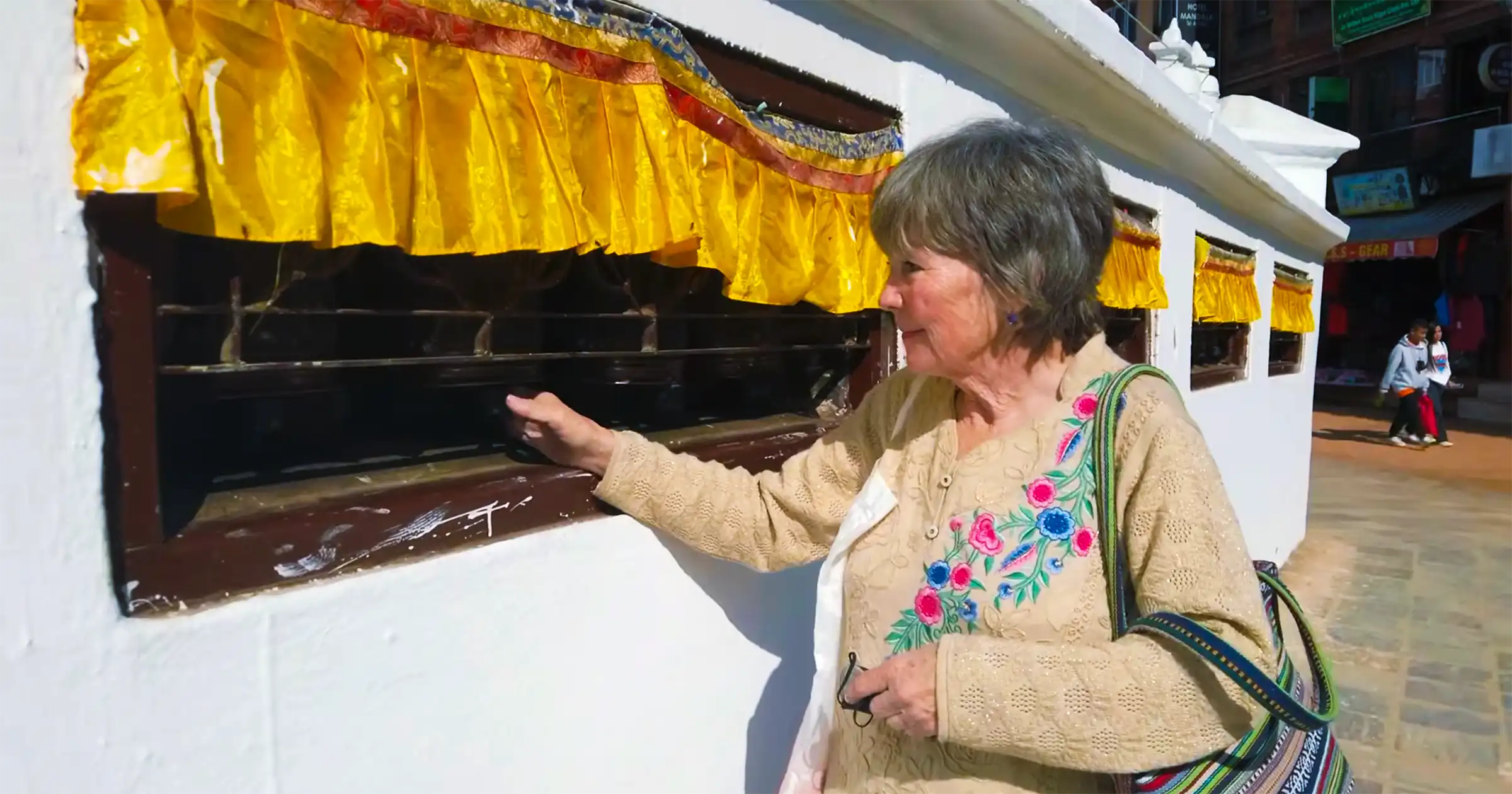 Tourist Spinning Prayer Wheels During Boudhanath Kora